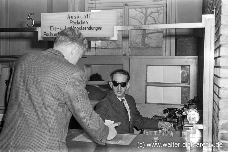 Kriegsblinder Postbeamter am Schalter 1958
