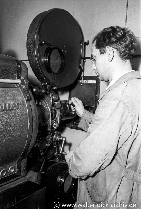 Filmvorführer an einem Kinoprojektor 1956