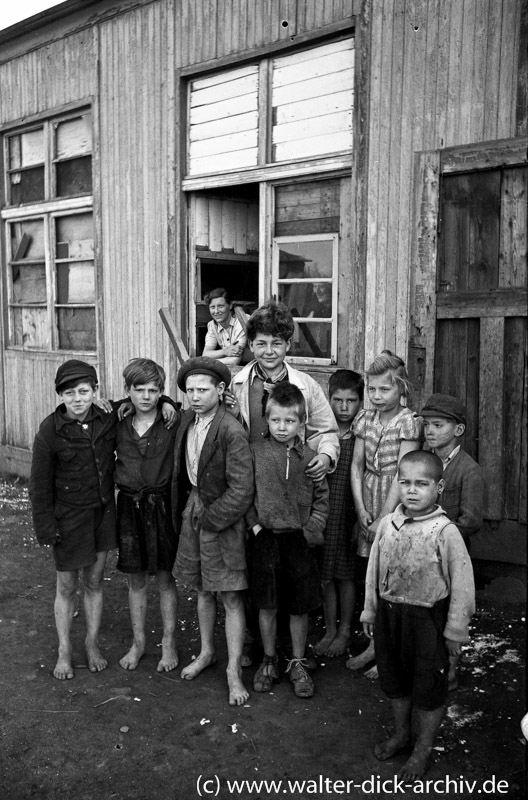 Kinder ohne Schuhe vor einer Baracke in Köln